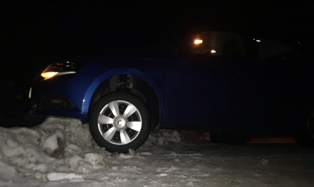 Blue car stuck on a snow pile at the end of the driveway before I got locked out.
