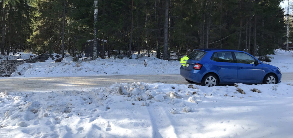 The morning after I was locked out, the blue hatchback car was safely parked on the street at the end of my snow covered driveway with a neon reflective vest on the back windshield.